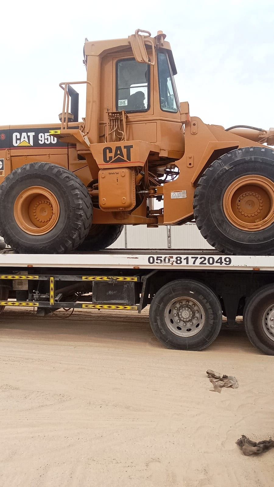 Caterpillar 950 wheel loader secured on an Axom Transport low-bed trailer ready for site delivery